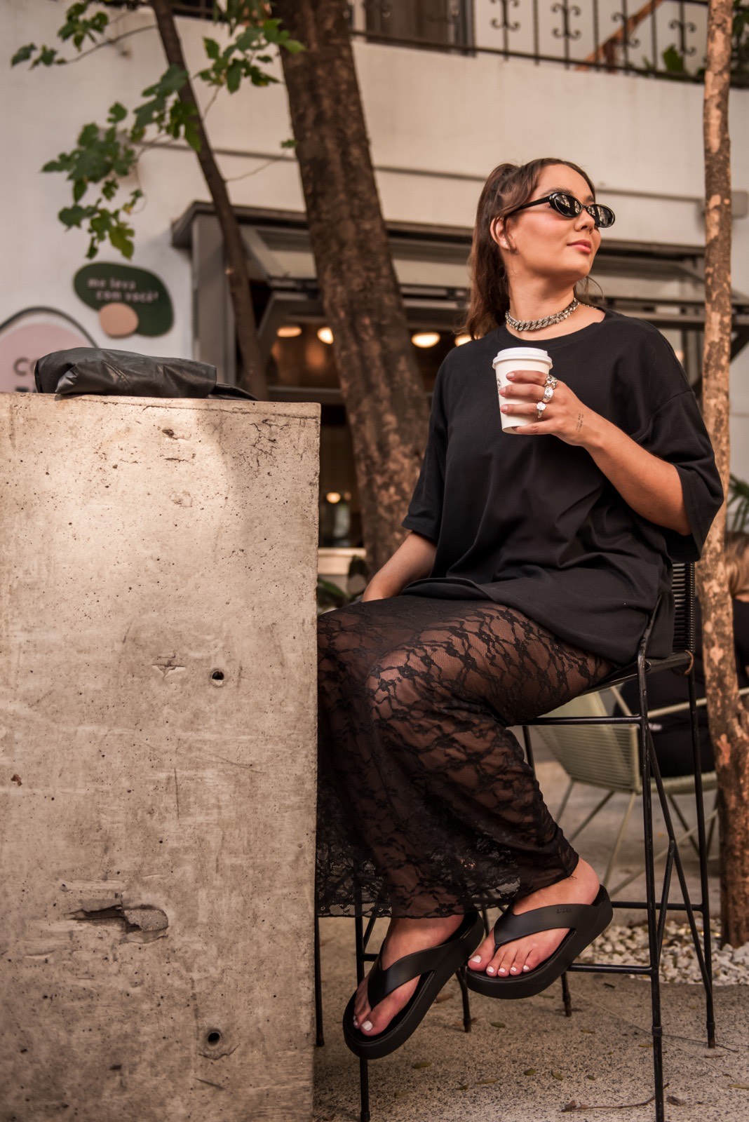 mulher estilosa tomando cafe na rua